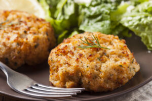 Fresh crab cakes on plate with salad