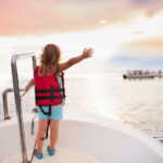 Kid in life vest sailing on a boat