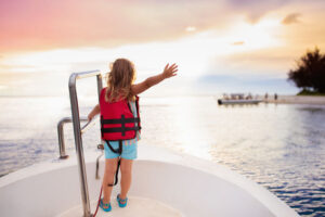 Kid in life vest sailing on a boat